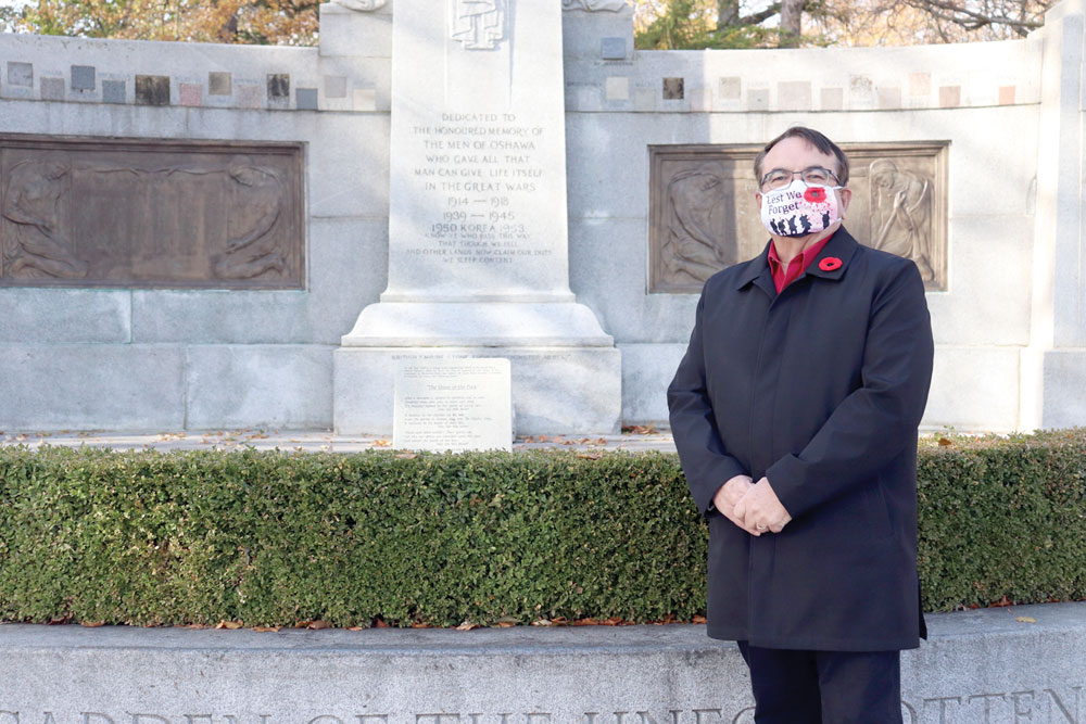 Oshawa deputy mayor Bob Chapman standing in front of the cenotaph at Oshawa Memorial Park.