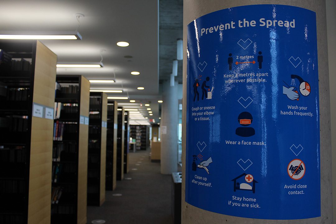 COVID-19 safety guideline posters are hung around the Durham College/UOIT library
