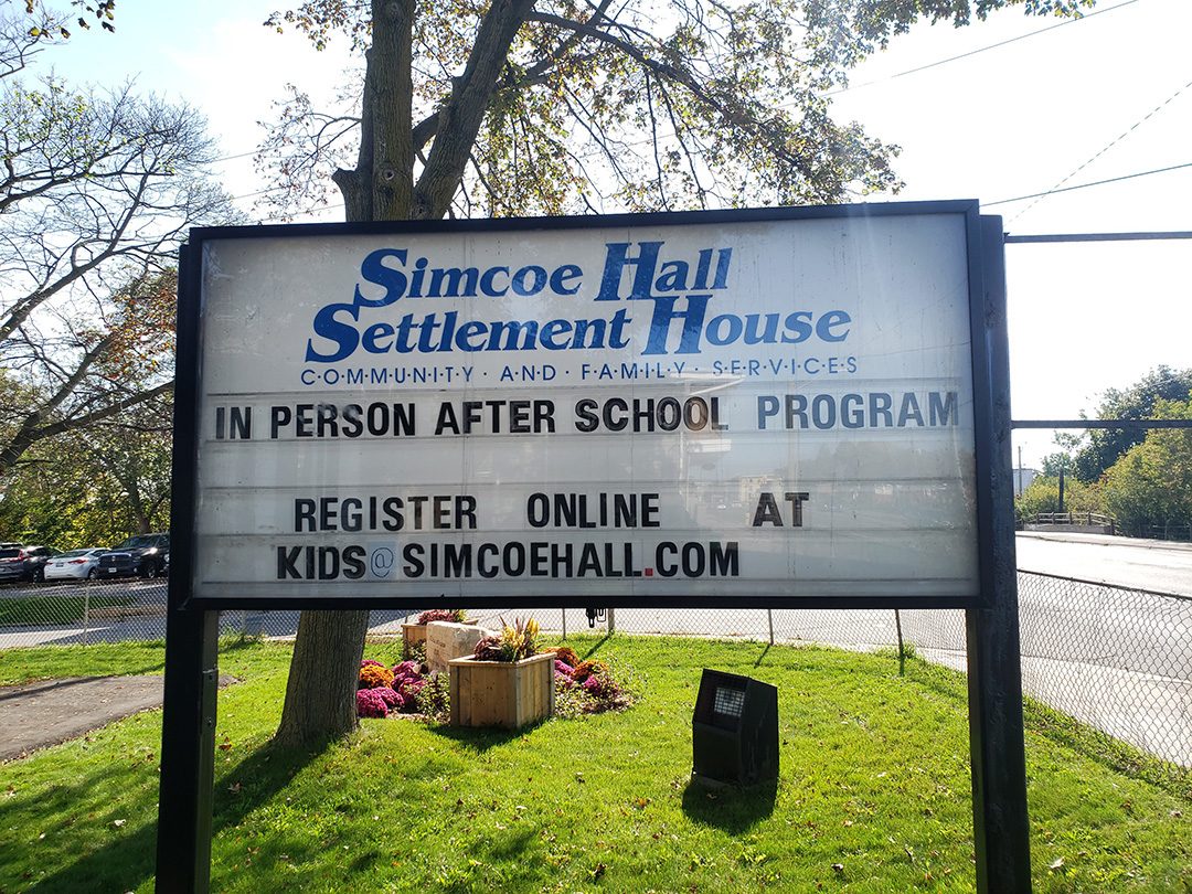 Simcoe Hall Settlement House's sign presents updates to the Oshawa community about ongoing events and programs.