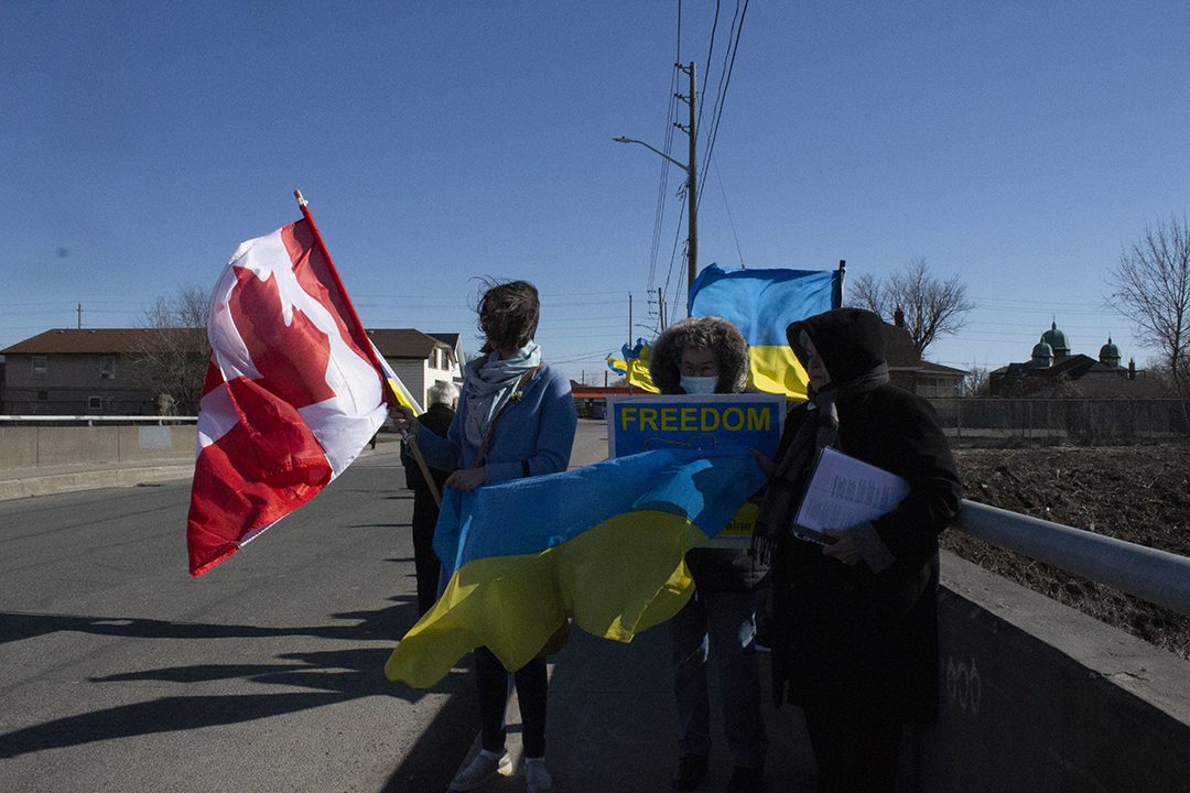 UCC rally organizers hold flags and signs.