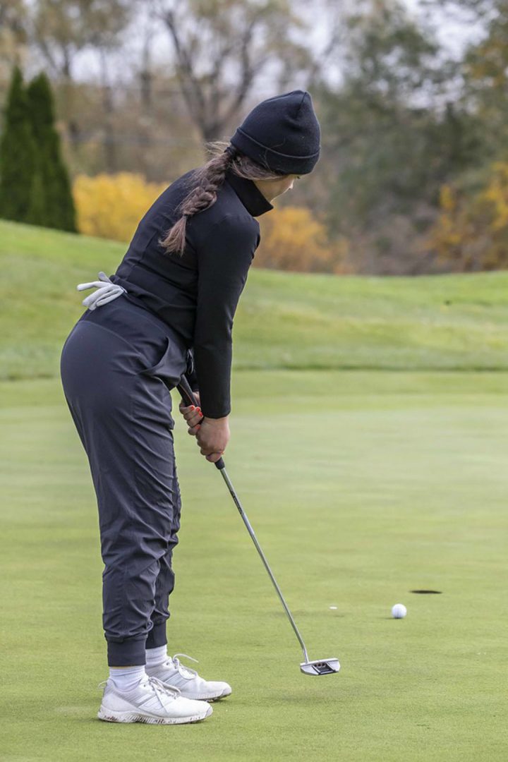 10/19/2022 - Devyn Fraser of the Lords' golf team watching her ball roling towards the hole on the 18th at Deer Creek Golf Club.
