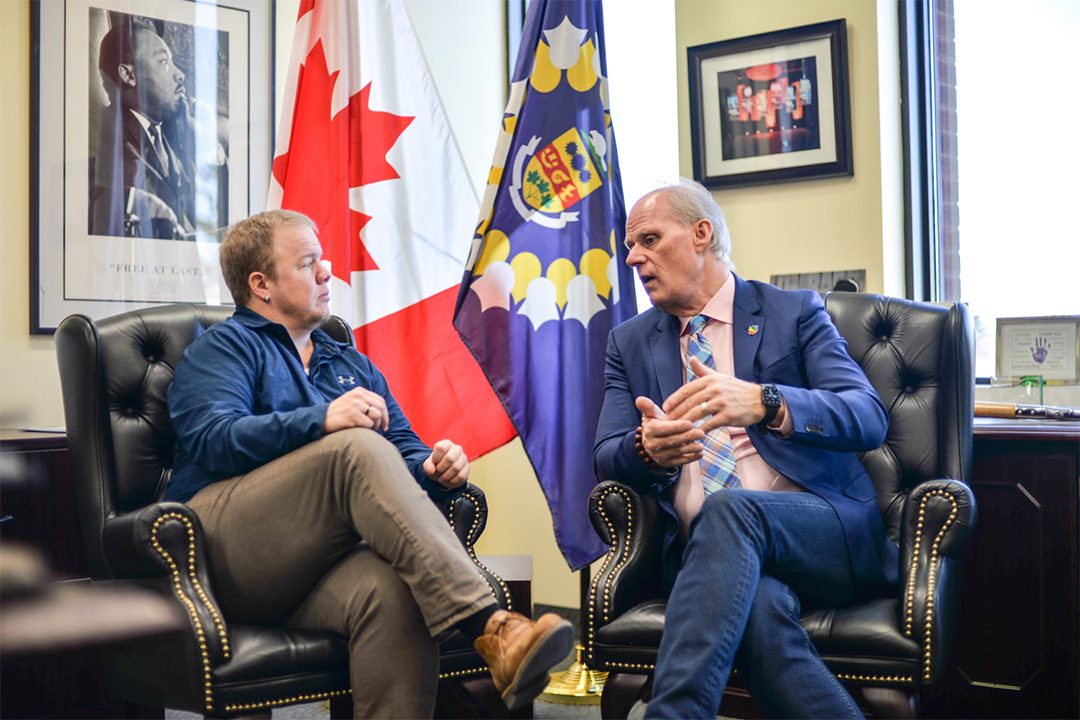 Jake Farr sits with Oshawa mayor, Dan Carter, during a meeting