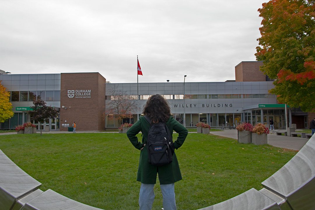 Bircke posing outside the Gordan Willey building on Oshawa campus.