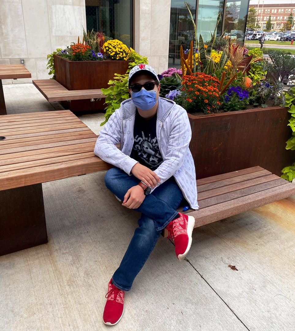 Ahmed Gamal posing outside the Ontario Tech/Durham College science building. The university provides a seat area outside for students and Gamal loves the space. The flowers and plants provides him a sense of calmness.