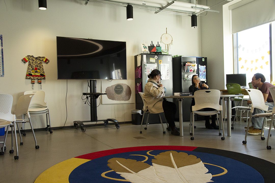 Students and Indigenous success coach, Jocelyne Pelletier, playing cards in the FPIC.