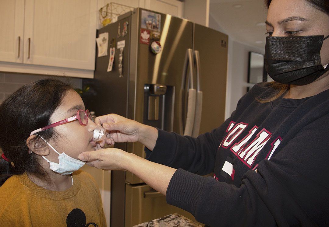 Sadia giving her daughter medicine to help with her symptoms