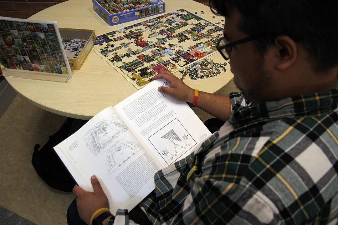 Marcus Nieva reading a history book in the Trent Durham library.