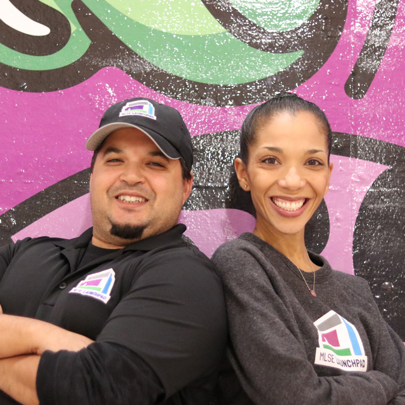 Marika Warner, Director of Research and Evaluation at MLSE, and Bryan Heal, Social Impact Research Lead at MLSE, posing for a photo at MLSE LaunchPad's headquarters.