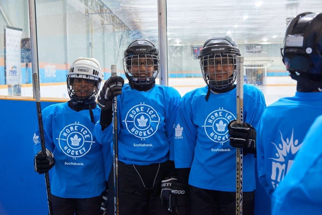 Kids from the 'Home Ice Hockey' program at MLSE Foundation posing for a photo in the middle of a session.