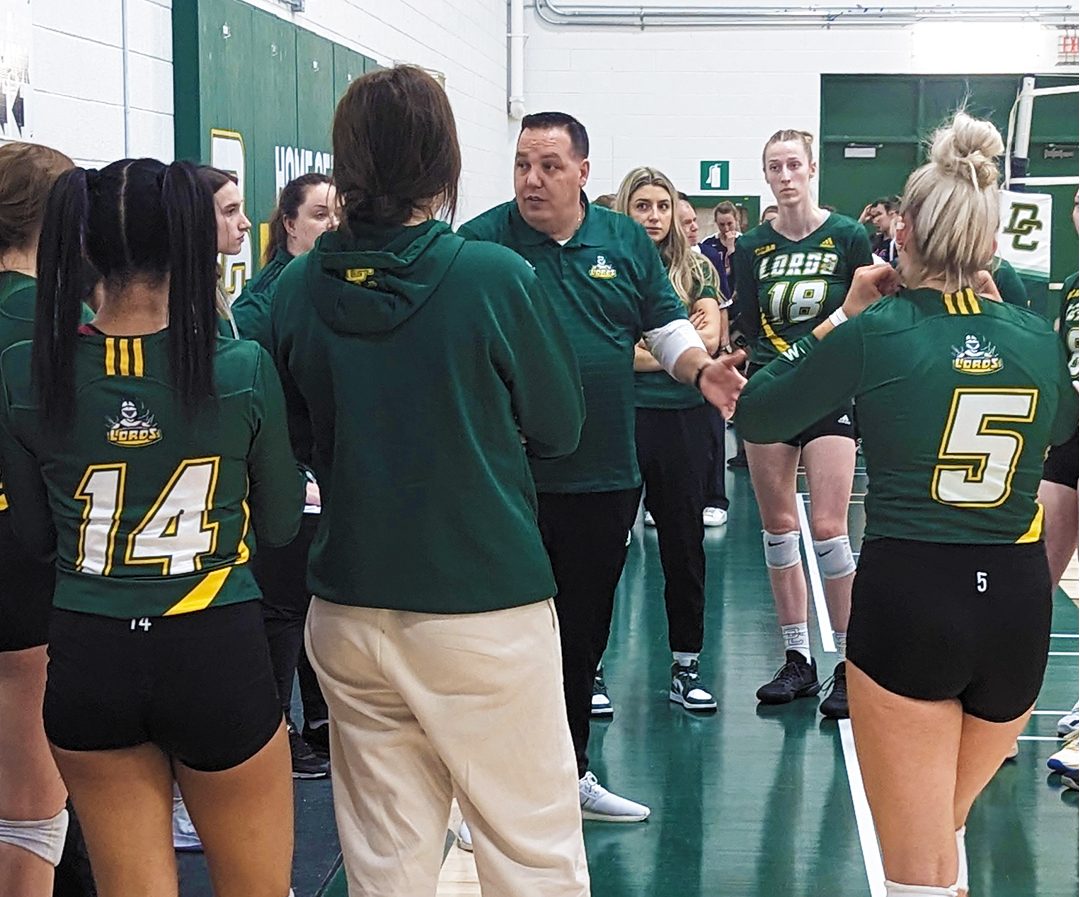 Women's volleyball coach, Tony Clarke, gives the team a pep talk during a timeout during a Round Robin match against Redeemer.