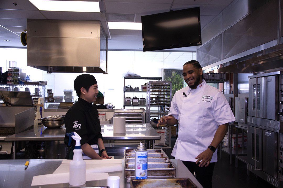 Tre Sanderson speaks with Gobby Tong, a second-year culinary student, who said she had a lot to learn from Sanderson. Sanderson has inspired Tong to aim high and perhaps open her own restaurant when she graduates this summer.