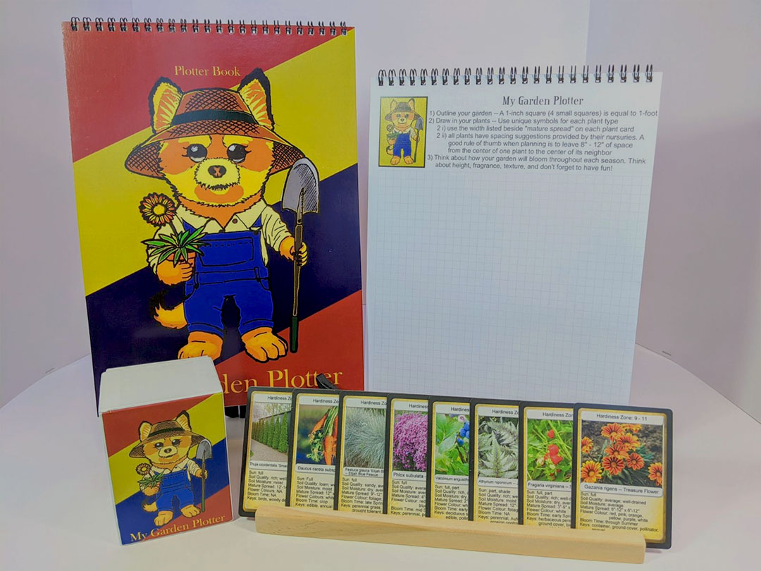 McCready's finished project is seen on display at the RBC showcase.
The garden plotter workbook is red, yellow, blue, and green, with a drawing of a bear-gardener placed on the front cover. 
The bear is wearing a straw hat and blue overalls. The bear is holding a flower pot in one hand and a shovel in the other hand.
Another workbook is placed beside the first one and is showing the inside of the workbook, which has some instructions listed in it on top of a graph sheet.
The deck of plant playing cards in displayed in front of both workbooks, there are eight cards shown in this photo, all of which have different plant photos and descriptions written on them.