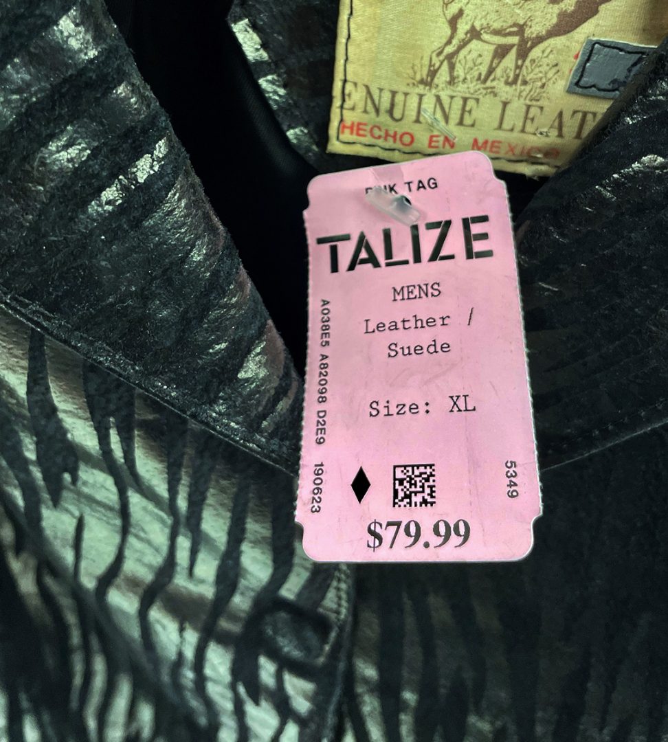 An aged jacket with a silver zebra print hangs in the Talize store's clothing section.