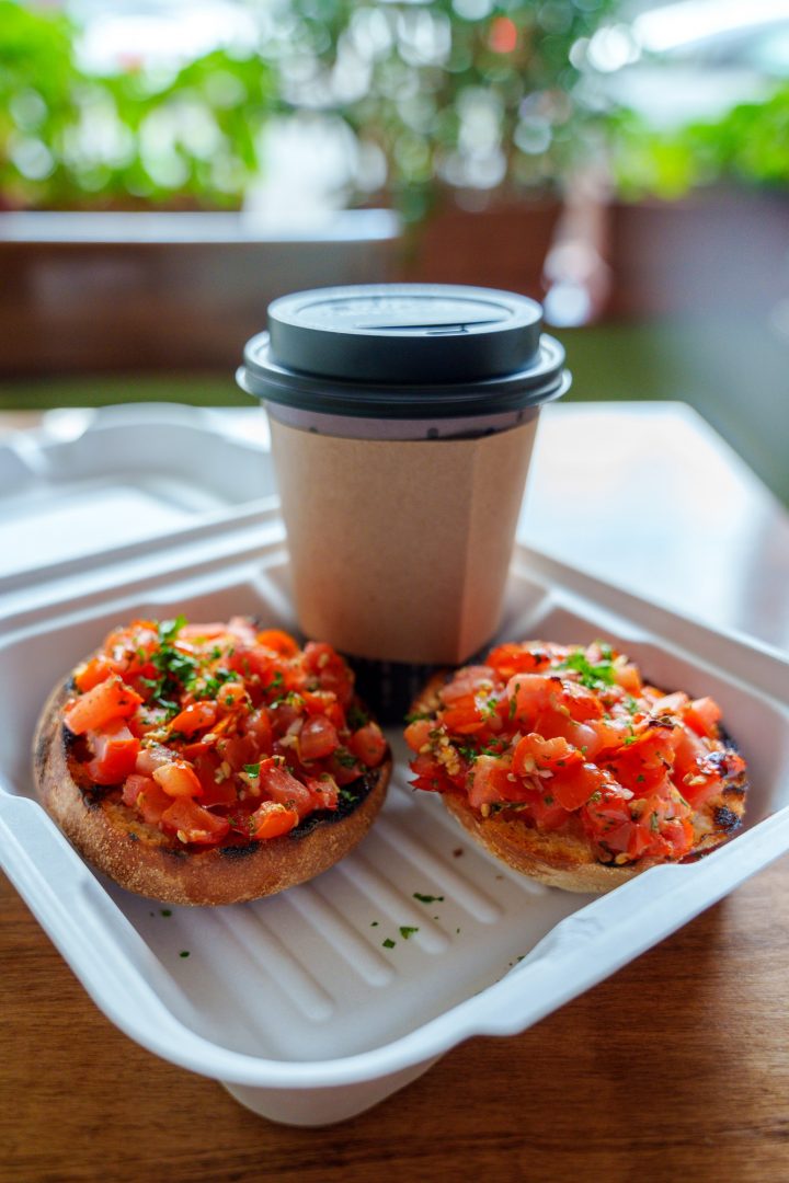 A takeaway container with two pieces of bruschetta toast and a disposable coffee cup in Nice Bistro, Whitby.