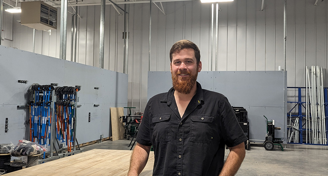 Picture from the waist up of New Democrat Party candidate Chris Borgia at Local 353 International Brotherhood of Electrical Workers in Oshawa.

Smiling and standing in front of the tools of his trade. In front of electrician equipment.