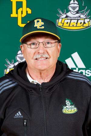 Sam Dempster stands for a headshot in front of the Durham Lords background wearing a Durham College baseball cap and a black Durham Lords windbreaker.