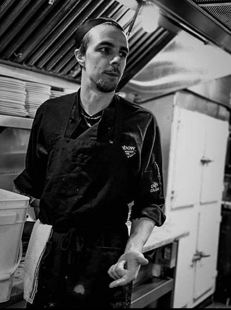 A black and white photo of Jacob Powless in a kitchen