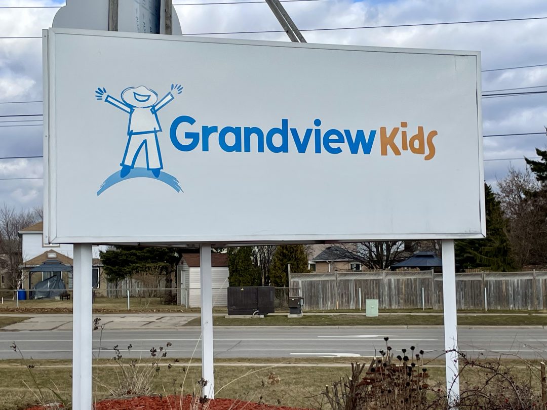 A welcome that says "Grandview Kids" beside a roadway.