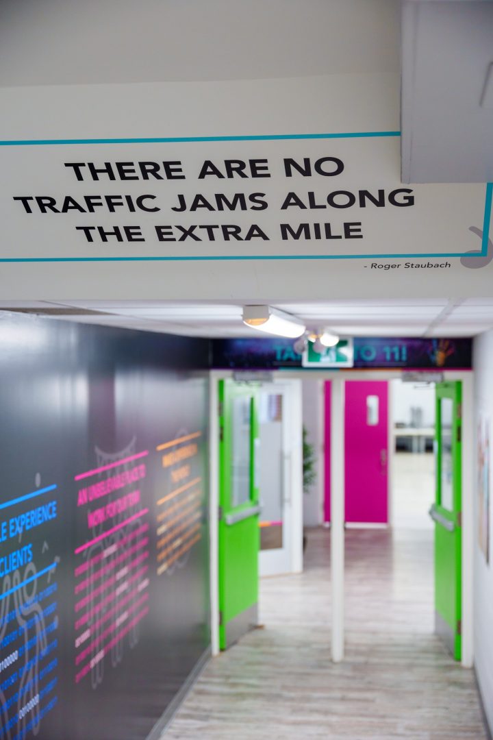 A photo of a hallway at the 360 Insights head office with a vinyl sticker on the ceiling that reads, "There are no traffic jams along the extra mile."