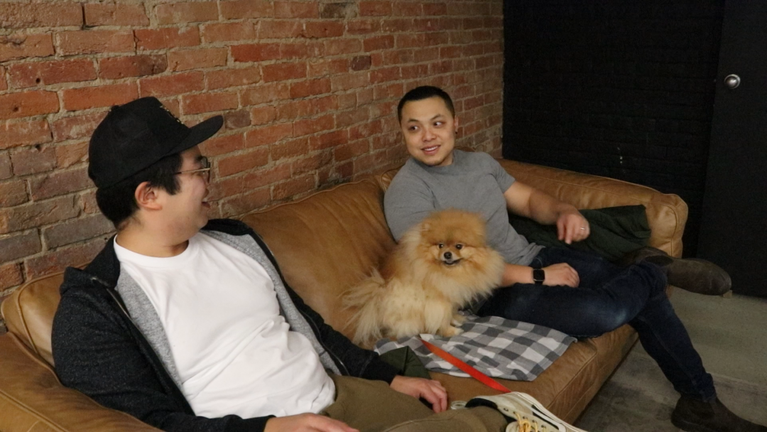 Derek Chung(left) sits beside Trevor Xue(right) with Derek's dog Rex sitting between them.