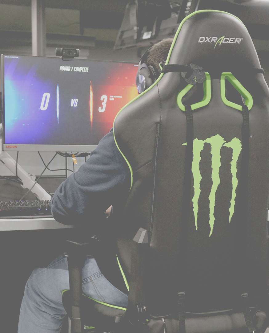 A Durham College student facing towards the PC playing overtime at Esports Arena, Durham College.