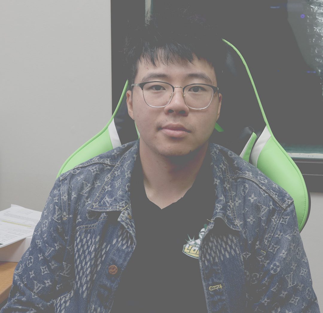 A picture of Bill Ai, general manager of Lords Esports gaming space at Durham College sitting in his office.