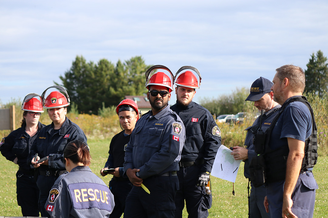 A group of OVERT members stand together in an open clearing.