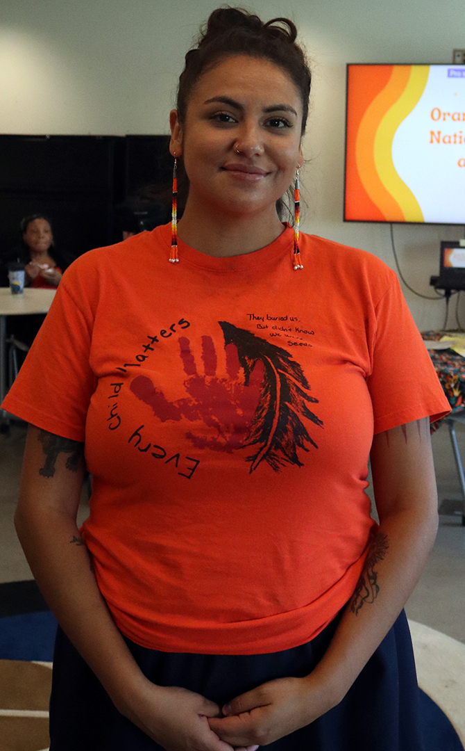 Indigenous spoken word poet Sarah Lewis standing in the First People&squot;s Indigenous Centre at the Durham College Oshawa campus. She is wearing an Orange shirt that says "Every Child Matters".