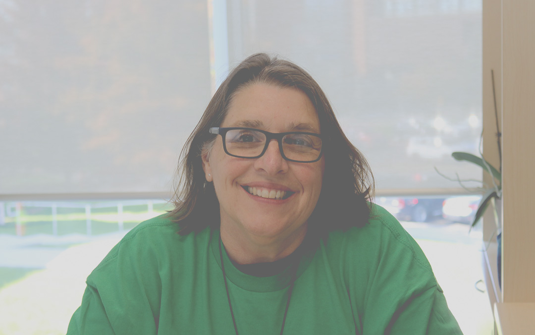 Leslie Linstrum, the writing specialist posing for the camera at her office.