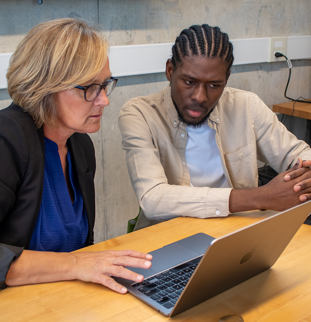 Emmanuel Echoga and Danielle Harder of Enactus Durham College are reviewing plans on a laptop.