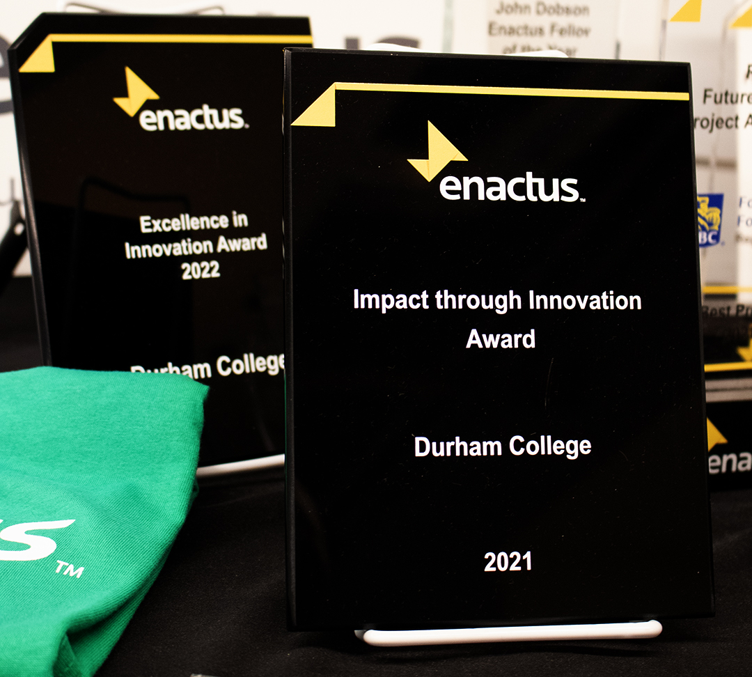 Two Enactus awards, with the main award reading “Impact Through Innovation.”