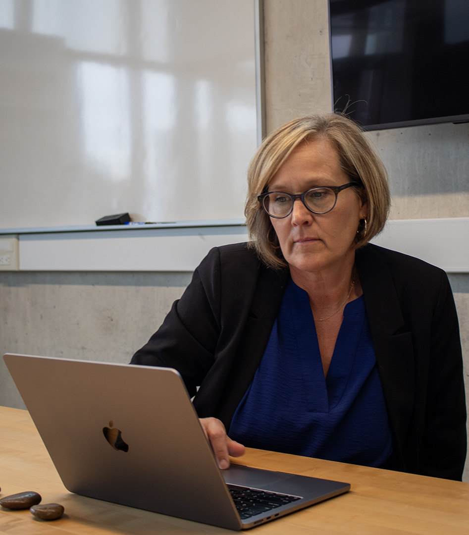 Danielle Harder, Faculty Advisor for Enactus Durham College, looking at her laptop working.