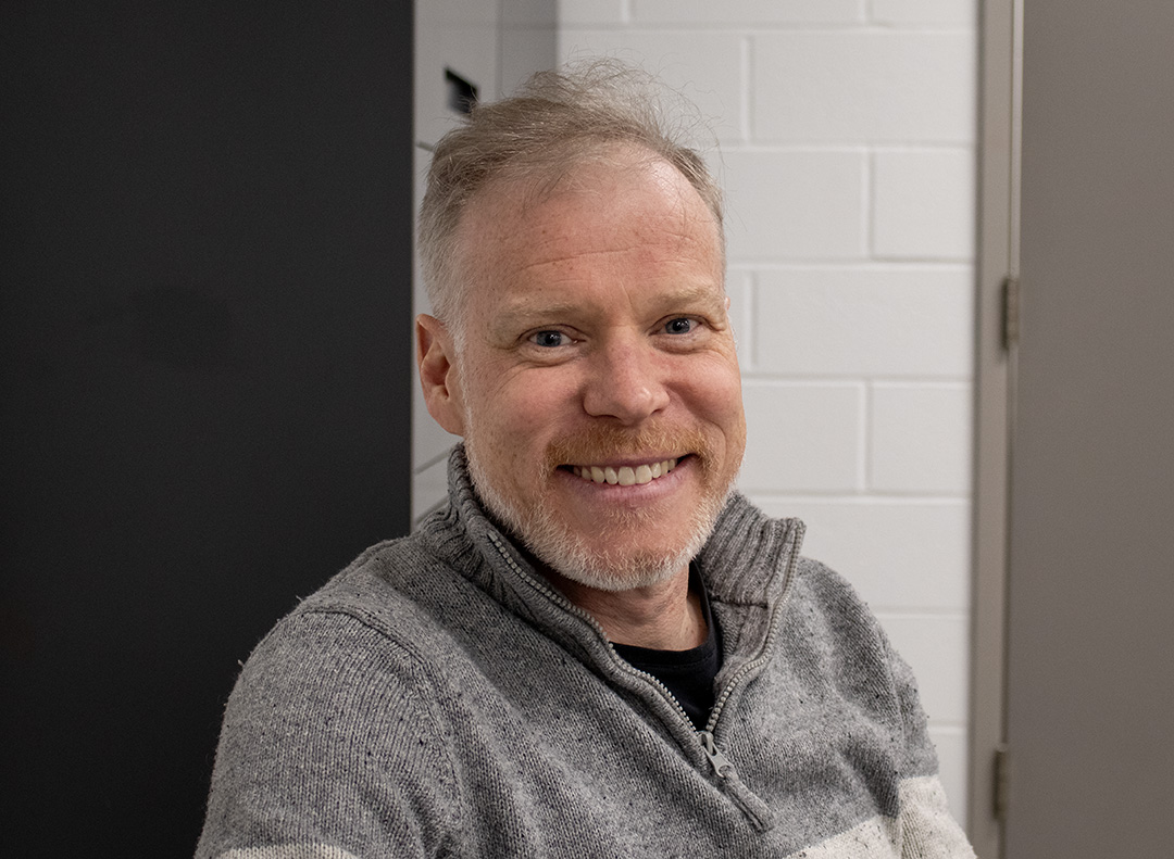 Kenyon Wallace, a reporter at the Toronto Star, is captured looking directly into the camera with a warm smile.