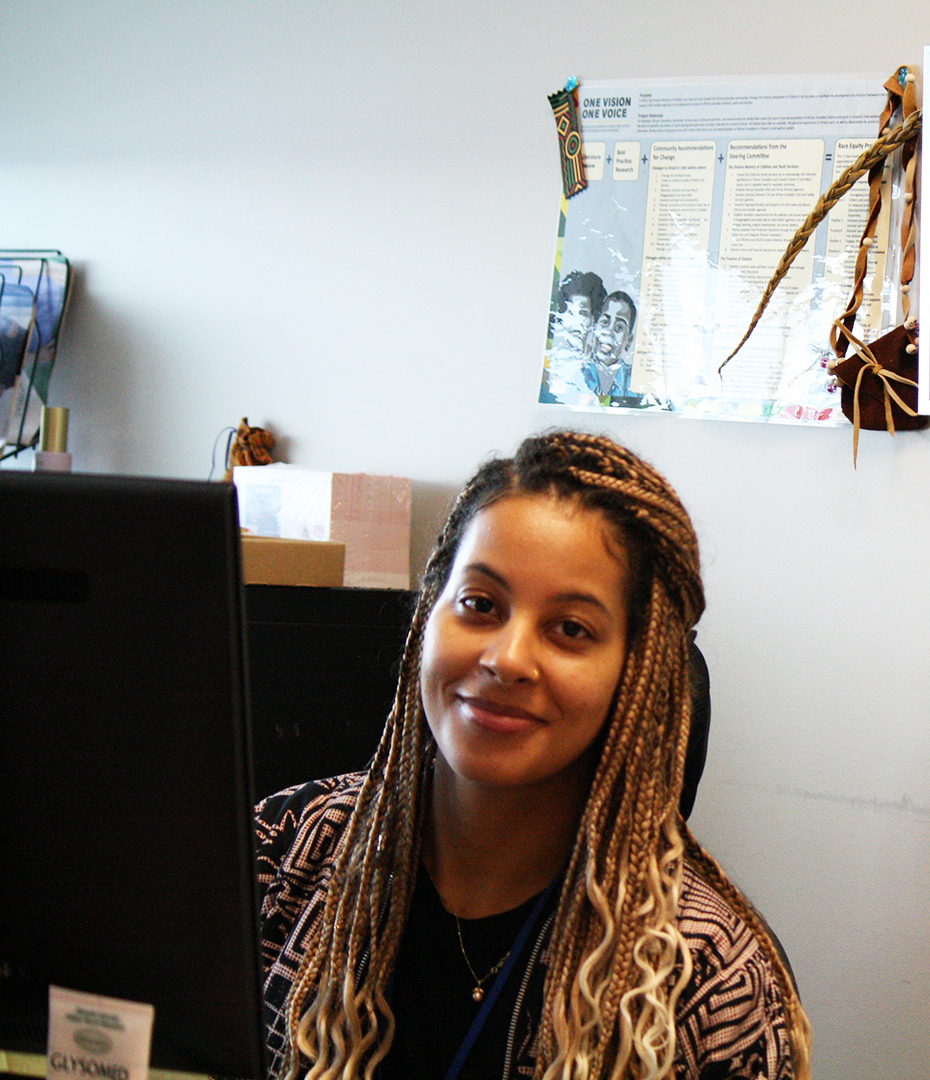 Shailene Panylo at work in her office at Durham Children's Aid Society in Oshawa, Ont. on Dec. 5, 2024. On the wall behind her is a poster for One Vision One Voice.