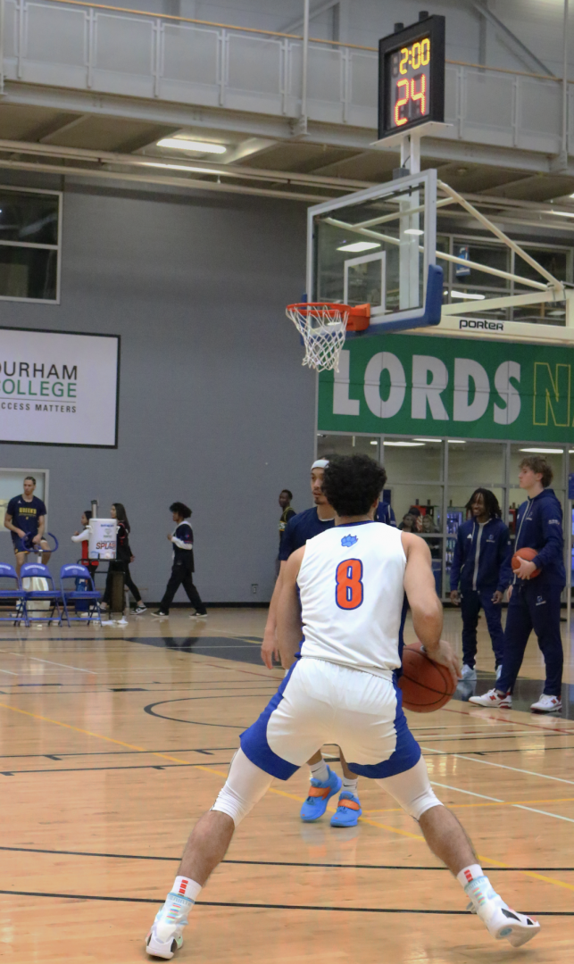 Ontario Ridgebacks men's basketball player #8 Avedis Karagavour holds the ball during practice, preparing for a shot before the game begins. Photo by Cristina Romeo.