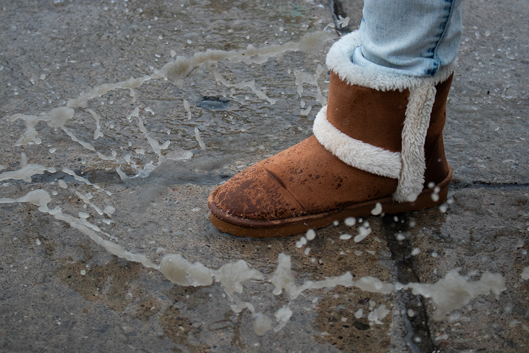 A student stomps in a pile of slush on the sidewalk at Durham College in Oshawa, Ont. on Jan. 16, 2025.