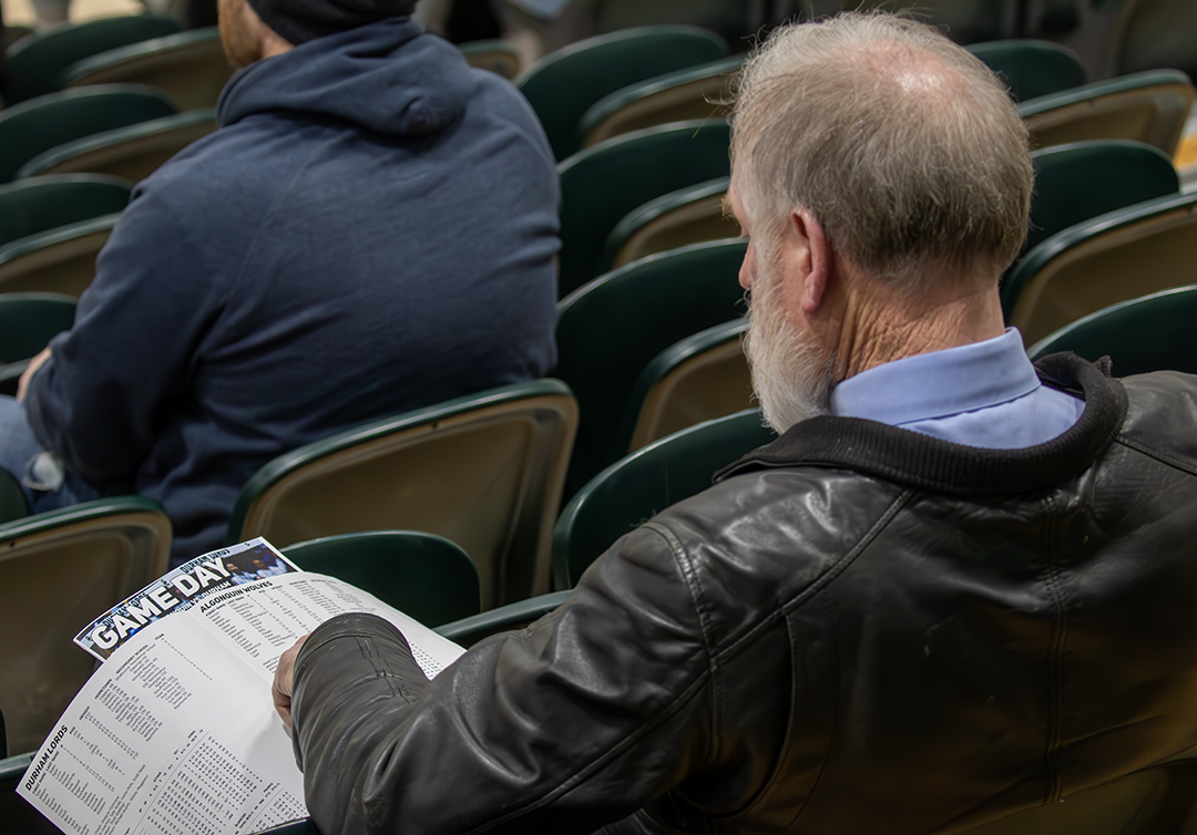 A spectator looking at the team stats ahead of Durham’s showdown against Algonquin on Sunday, Feb. 2,  at Durham College in Oshawa, Ont.