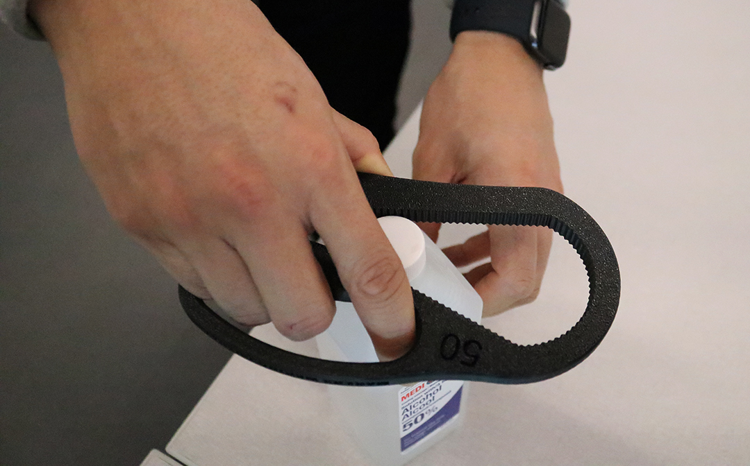 A library employee using an assistive device to open a bottle at the McLean branch of the Ajax Public Library in Ajax, Ont. on Feb. 11, 2025.