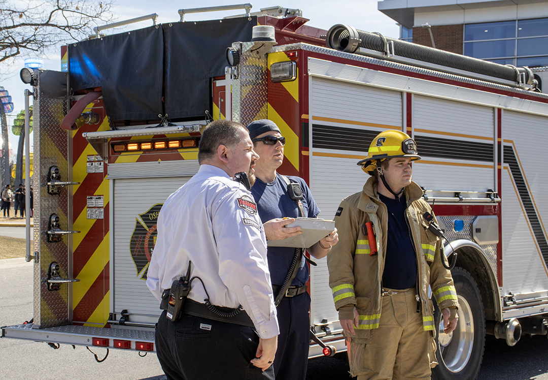 Security and Fire Marshals discuss the situation outside the building.