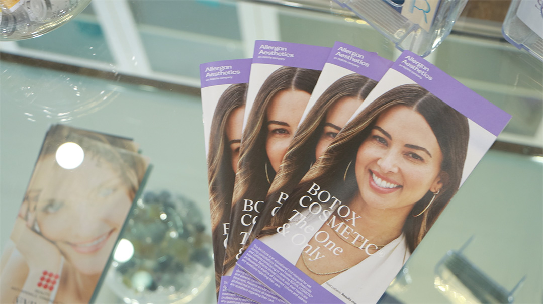 Botox cosmetic treatment pamphlets laid on glass table.