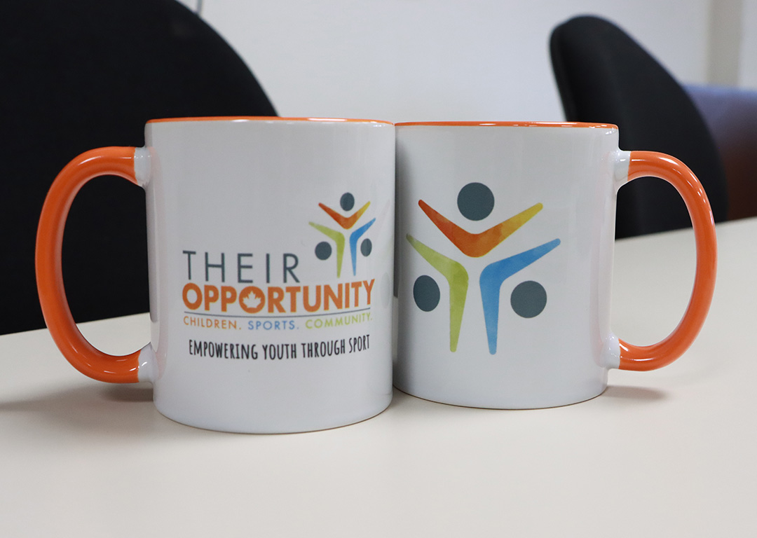 Their Opportunity branded mugs sitting on table at Their Opportunity Charity HUB in Oshawa on December 4th, 2025.