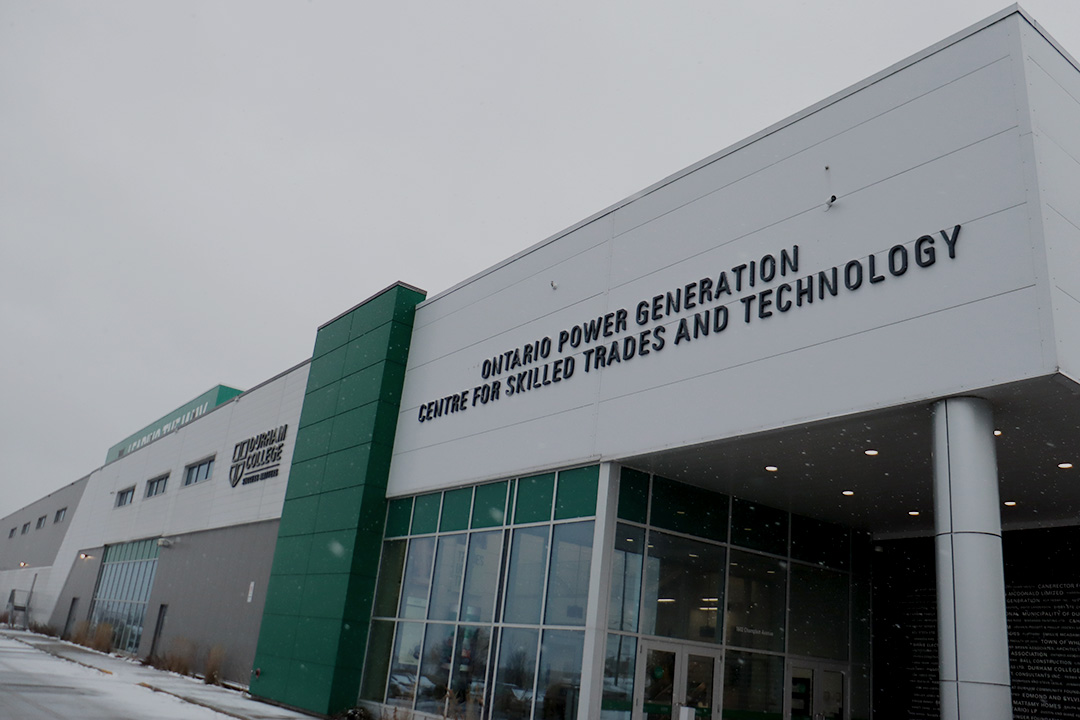 A white building with green trim on a cold day. The sign on the building reads "Ontario Power Generation Centre for Skilled Trades and Technology."
