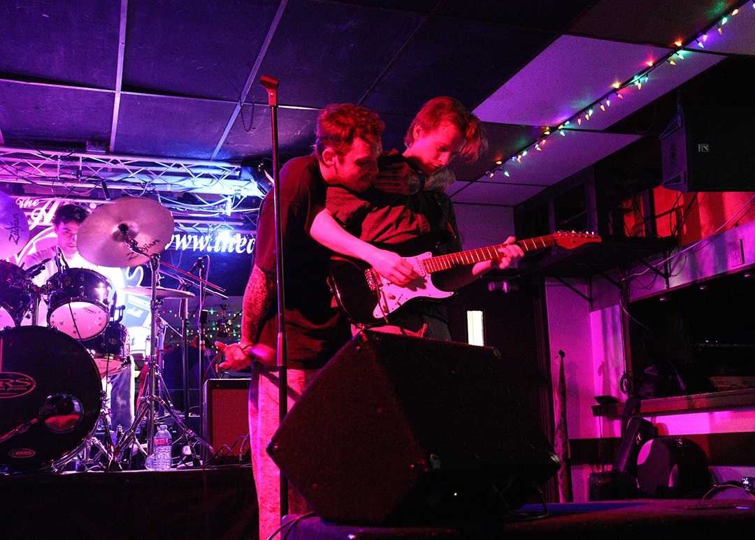 Two band members hug as they perform at the Atria.