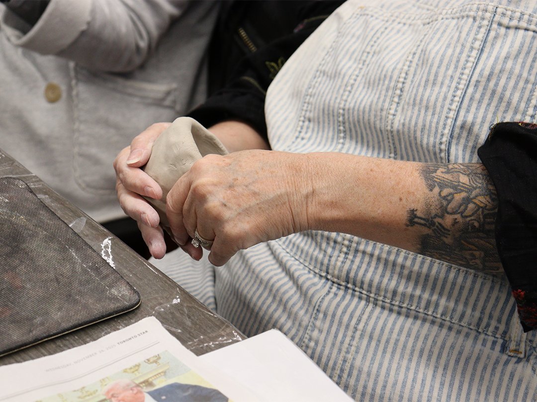 A woman's hands shaping a clay cup.
