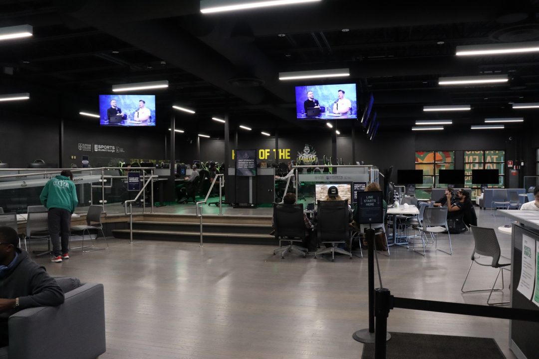 A large room with chairs and video game equipment, including large screens.