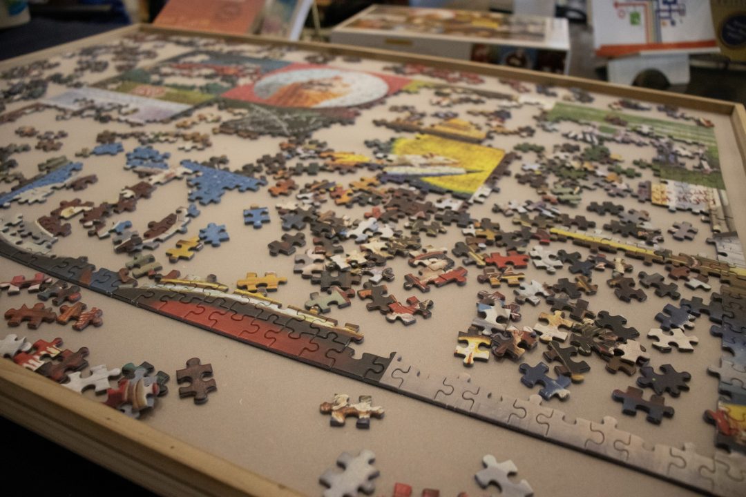 A half-completed puzzle sits on a beige table.